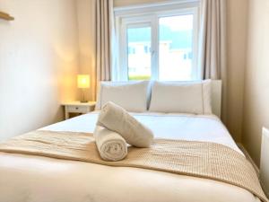 a bed with a towel on it with a window at Anchors Rest, Cobh in Cobh