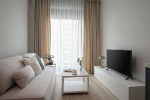 a living room with a couch and a flat screen tv at Aparthotel Symphony Krakowska 35 by INA in Wrocław