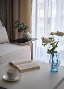 a living room with a couch and a table with a book at Aparthotel Symphony Krakowska 35 by INA in Wrocław