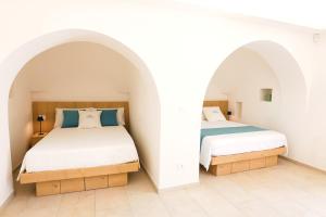 two beds in a room with white walls at Resort San Giacomo con Piscina in San Michele Salentino +82 photos