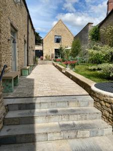 a stone path between two buildings with a bench at Number One Bruton in Bruton
