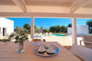 a table with a plate of food on a patio at Resort San Giacomo con Piscina in San Michele Salentino