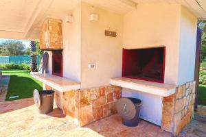 an outdoor pizza oven with a stone fireplace at Resort San Giacomo con Piscina in San Michele Salentino