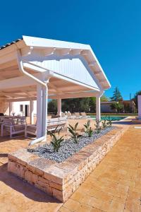a white pavilion with chairs and tables under it at Resort San Giacomo con Piscina in San Michele Salentino
