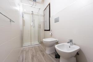 a white bathroom with a toilet and a sink at Al Lago da Lilly in Gargnano