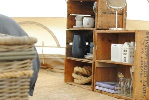a wooden book shelf with dishes and a mirror at Cosy Tents - Daylesford in Yandoit