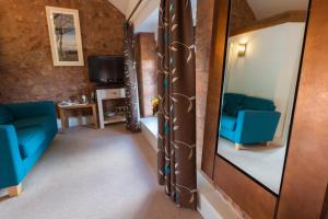 a room with two blue chairs and a mirror at The Old Dairy at Bishops Barton in Wellington