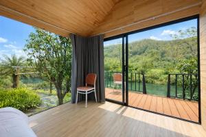 a bedroom with a view of a balcony with glass doors at Orchid Villa & Homestay Farm Lăng Cô in Thôn An Cư Ðông