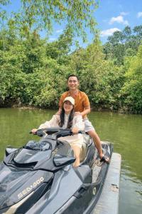 a man and woman sitting on a speed boat on the water at Orchid Villa & Homestay Farm Lăng Cô in Thôn An Cư Ðông