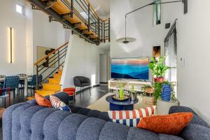 a living room with a blue couch and a tv at Villa de rêve - Climatisation - Sauna - Spa - babyfoot - Arcade in Quatzenheim