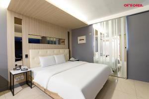a bedroom with a large white bed and a bathroom at INCHEON AIRPORT HOTEL THE ONe in Incheon