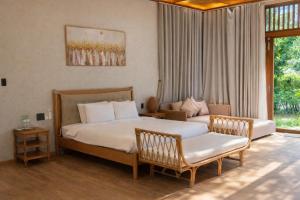 a bedroom with two beds and a chair and a window at Orchid Villa & Homestay Farm Lăng Cô in Thôn An Cư Ðông