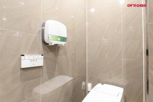 a bathroom with a toilet and a soap dispenser at INCHEON AIRPORT HOTEL THE ONe in Incheon