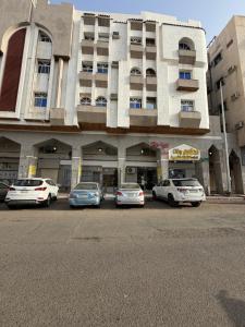 a group of cars parked in front of a building at SAMA Economic Apartment in Medina