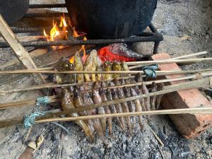 a bunch of sticks cooking food over a fire at little Island in Na Lúng
