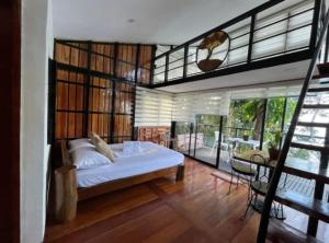 a bedroom with a large bed and a balcony at My Honey's Farm in Nangkaan