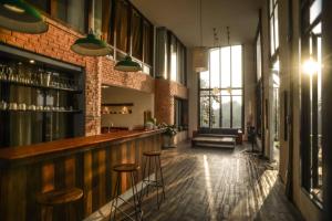 a bar with stools in a room with a brick wall at Baantidnam in Ban Thung Tho