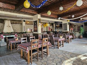 ein Restaurant mit Holztischen und -stühlen in einem Raum in der Unterkunft Hotel Olimpija plus in Herceg-Novi