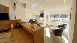 a kitchen and living room with a table and chairs at Luxus Terrassenappartement Berg & See 2 in Bodensdorf