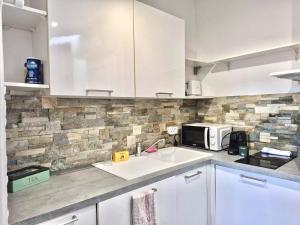 a kitchen with a sink and a microwave at Cozy Bosio - Studio de charme Cours Saleya in Nice