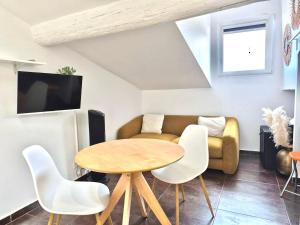 a living room with a table and a couch at Cozy Bosio - Studio de charme Cours Saleya in Nice