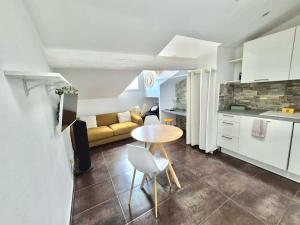 a kitchen and living room with a table and a couch at Cozy Bosio - Studio de charme Cours Saleya in Nice