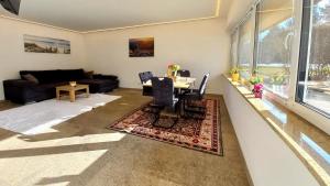 a living room with a table and a couch at Luxus Terrassenappartement Berg & See 2 in Bodensdorf