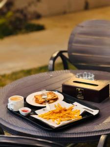 a table with a plate of food and french fries at Holiday One Hotel & Suites - DHA-8 in Karachi