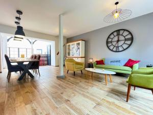 a living room with a couch and a table and a clock at Villa LES MYRTILLES in Cabourg