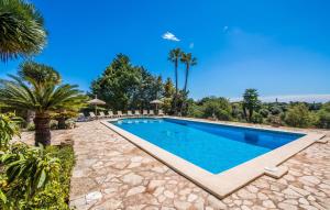 a swimming pool in a resort with palm trees at Can Palleta Nou in S'Horta