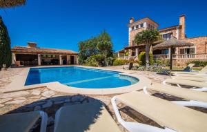 an outdoor swimming pool with lounge chairs and a house at Can Palleta Nou in S'Horta
