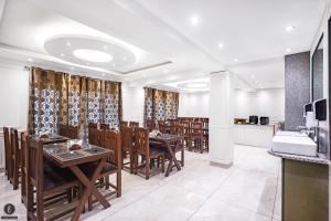a dining room with wooden tables and chairs at Hotel Classy Castle in Kolur
