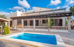 a villa with a swimming pool in front of a house at Pomeres Nou in Sa Coma