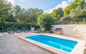 a swimming pool in a yard with chairs and a fence at Pomeres Nou in Sa Coma