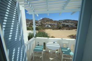 a balcony with chairs and a view of the beach at Ilias Place in Ios Chora