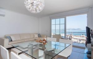 a living room with a glass table and a chandelier at Minimal in Can Picafort