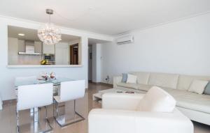 a living room with white furniture and a chandelier at Minimal in Can Picafort