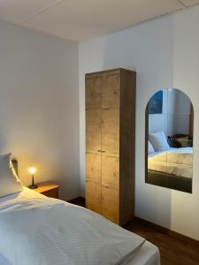 ein Schlafzimmer mit einem Bett und einer Kommode mit Spiegel in der Unterkunft Paciello Restaurant Hotel in Velbert
