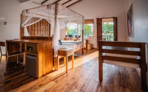 a bedroom with a canopy bed and a desk at C Beyond Nilaveli in Nilaveli