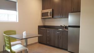 a small kitchen with a table and a refrigerator at Jewel City Inn in Glendale