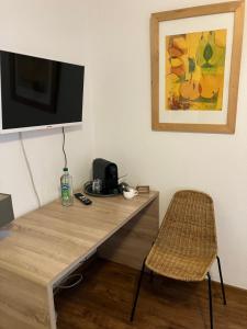 ein Schreibtisch mit Fernseher und Stuhl in einem Zimmer in der Unterkunft Paciello Restaurant Hotel in Velbert