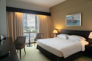 a hotel room with a bed and a desk and a window at Pan Borneo Hotel Kota Kinabalu in Kota Kinabalu +31 photos