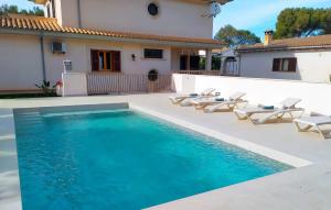 a swimming pool with chairs and a house at Calma De Son Serra De Marina in Son Serra de Marina