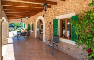 a patio with green shutters and a table and chairs at Es Campets in Sencelles