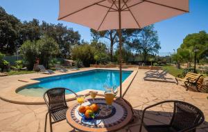a table with an umbrella next to a swimming pool at Es Campets in Sencelles