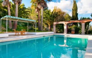 a swimming pool with a pergola and palm trees at Santa Maria in Artá