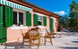 a patio with green shutters and a table and chairs at Santa Maria in Artá +34 photos