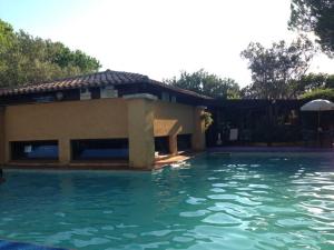 a swimming pool in front of a house at La casetta a due passi dal mare con spiaggia privata in Capo Coda Cavallo
