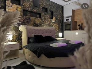 a bedroom with a large bed with purple pillows at Apartman Delux in Bačka Topola