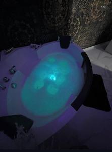 a bath tub filled with blue water in a room at Apartman Delux in Bačka Topola